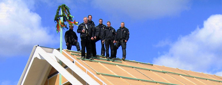 Schacht-Mitarbeiter auf dem Dach beim Richtfest